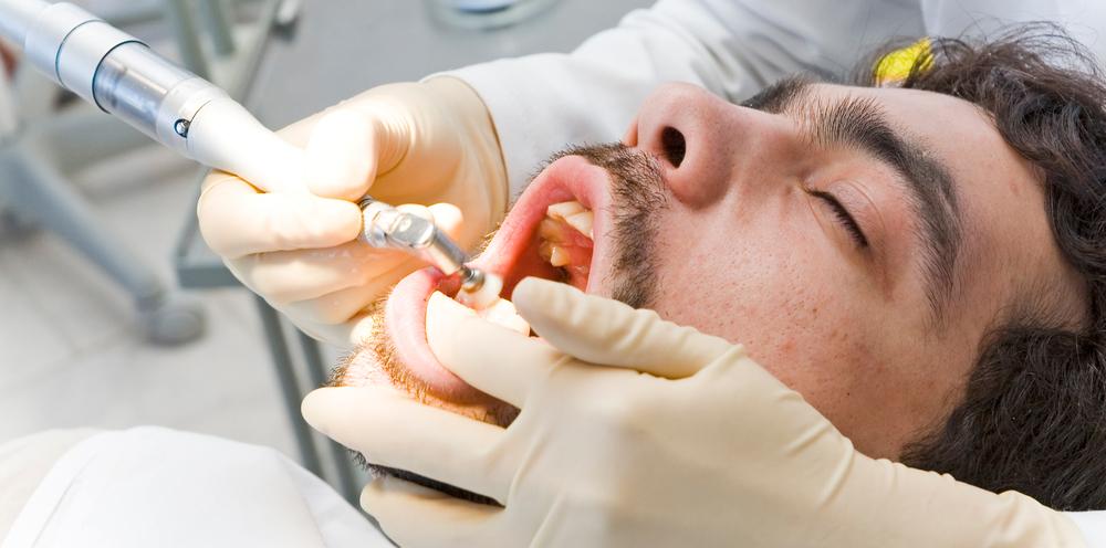 Dentist performing dental cleaning in preparation for a cosmetic dentistry procedure